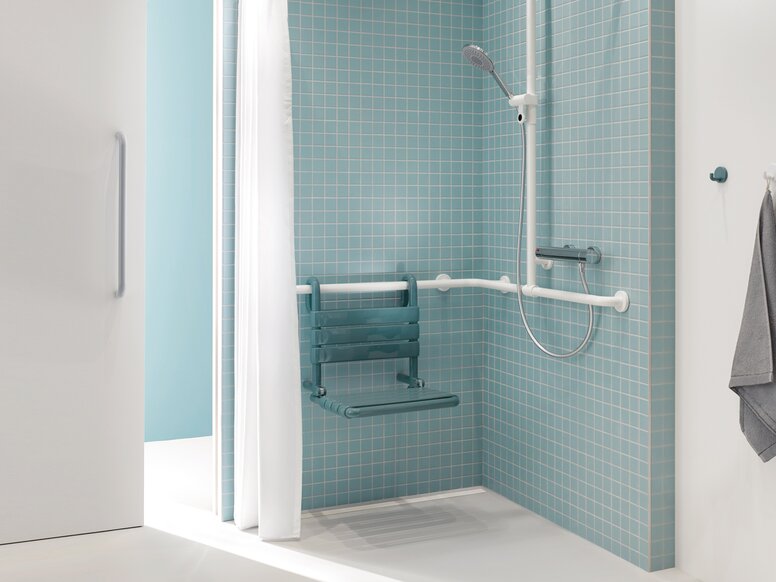 Patient bathroom with HEWI Series 477 Shower area of a patient bathroom in blue and white with a view through a sliding door