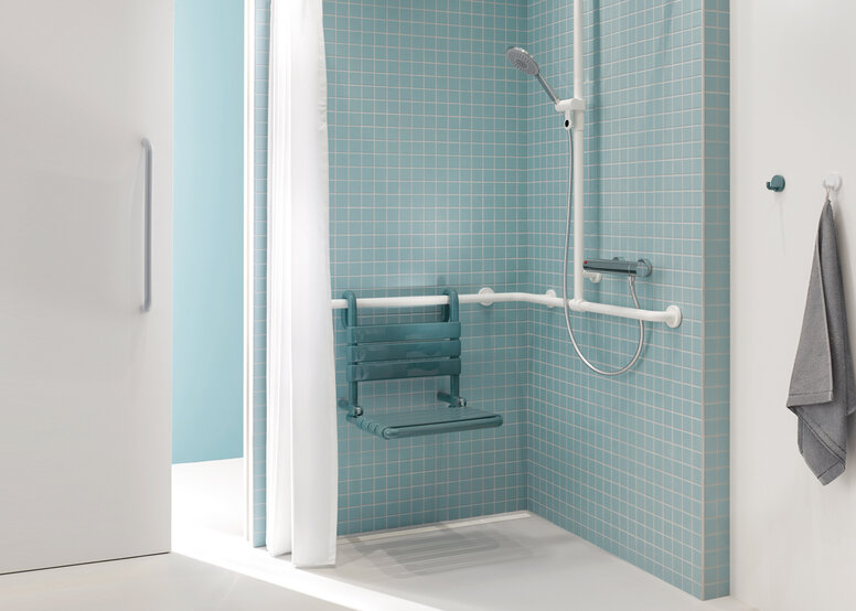 Patient bathroom with HEWI Series 477 Shower area of a patient bathroom in blue and white with a view through a sliding door